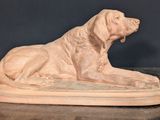 statue of a dog laying down on top of a marble slab