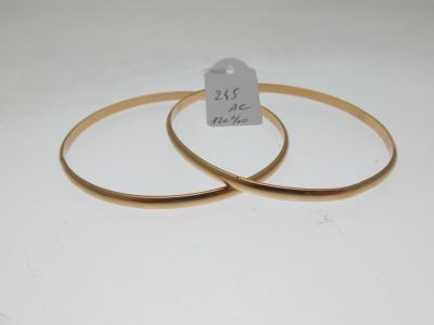 pair of gold tone bang bracelets with a price tag on a white background