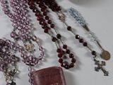 many rosary beads and a book laying on a table