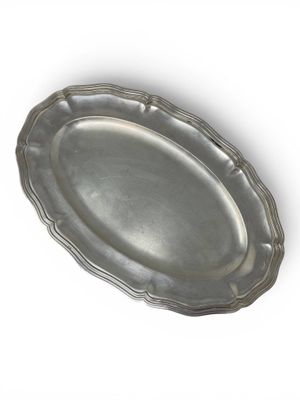 a silver plate with a decorative edge on a white background