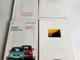 two brochures of a car and a car on a table