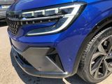 a close up of a blue car parked in a parking lot