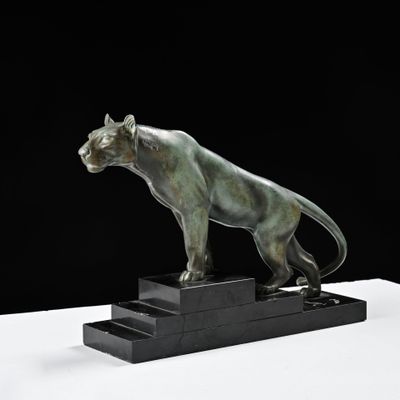 une image représentant une statue en bronze d'une panthère posée sur un socle noir