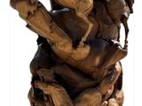 a wooden sculpture of horses on a rock with a sky background