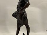 bronze statue of a man holding a book on a marble base