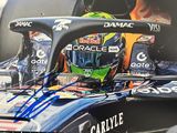 photo dédicacée d'une voiture de course avec un casque sur le capot