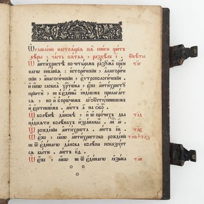 un vieux livre sur lequel figurent des inscriptions en noir et rouge