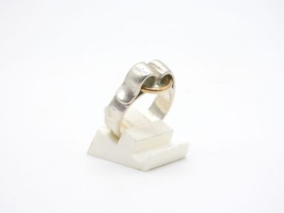 bague en argent massif posée sur un bloc de marbre blanc
