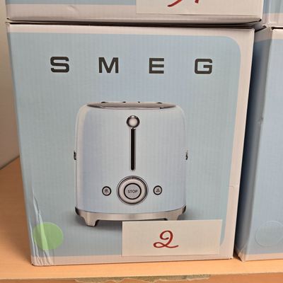 Des boîtes contenant des grille-pain sont empilées sur une étagère dans un magasin