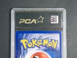 the pokemon card is in a plastic case on a table
