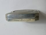 a silver lighter that is sitting on a white surface