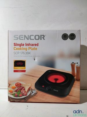 boîte contenant une plaque de cuisson infrarouge posée sur une table en bois