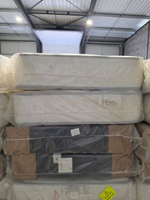 many mattresses stacked on top of each other in a warehouse