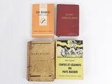 three books are sitting on a white surface, one of which is yellow and one of which is red