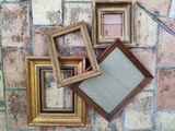 four picture frames sitting on a brick floor next to each other