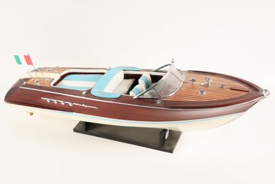 wooden model of a speed boat on a stand on a white surface