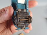 a person holding a small toy car in their hand