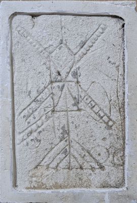 a stone plaque with a drawing of a windmill on it