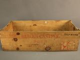 an old wooden crate sitting on top of a table next to a bottle of wine