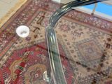 une table en verre avec un plateau en verre et un tapis posé au sol