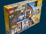a box with a lego creator set in it on a blue background