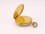 an old gold pocket watch with a chain on a white surface