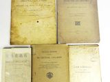 four old books sitting on top of each other on a table