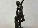 bronze statue of a woman holding a flower in her right hand