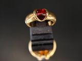 une bague en or avec une pierre rouge au centre