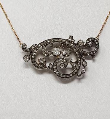 a gold and diamond necklace on a white surface