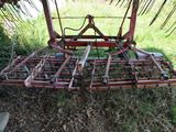 a tractor plow that is sitting in the grass