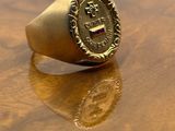 an image of a gold signet ring on a wooden table