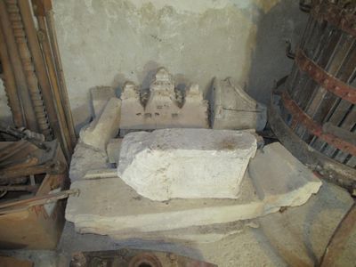 a stone sink in the middle of a room next to a barrel