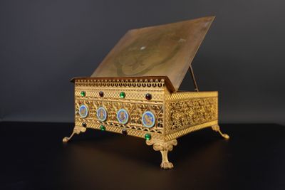 une image représentant une boîte dorée posée sur une table noire