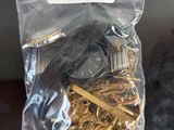 a bag of gold keys and a watch on a table
