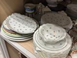 many plates and bowls sitting on a shelf in a room