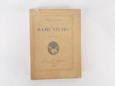 un vieux livre posé sur une table à côté d'un mur blanc