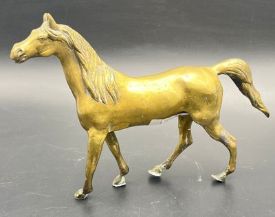statue of a golden horse on a gray surface