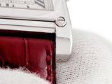 a close up of a wrist watch with a red strap