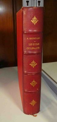un livre rouge posé sur une table blanche