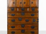 une vieille commode en bois avec de nombreux tiroirs sur le dessus