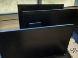 trois écrans d'ordinateur posés sur une table devant une fenêtre