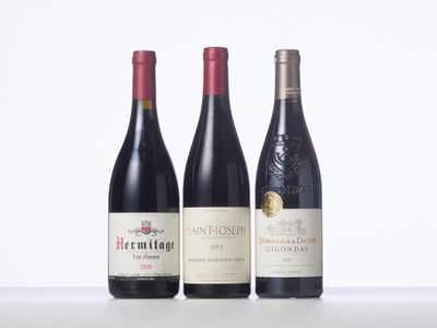 three bottles of wine are lined up on a table