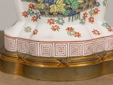 a white vase with a bird on it on a table