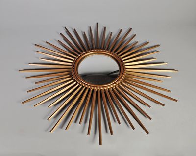 un miroir doré en forme d'étoile accroché au mur