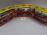 Trois trains miniatures encore dans leur boîte sont posés sur une table