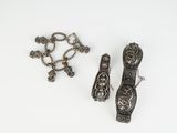 two pieces of silver jewelry on a white surface