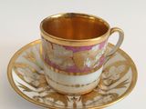 a cup and saucer on a saucer on a white table