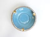 a blue cup and saucer sitting on a white table