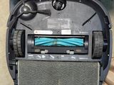 a robot that is sitting on the floor with a blue ribbon